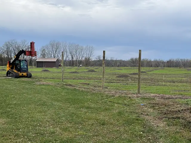Fence posts set in a row across an open field